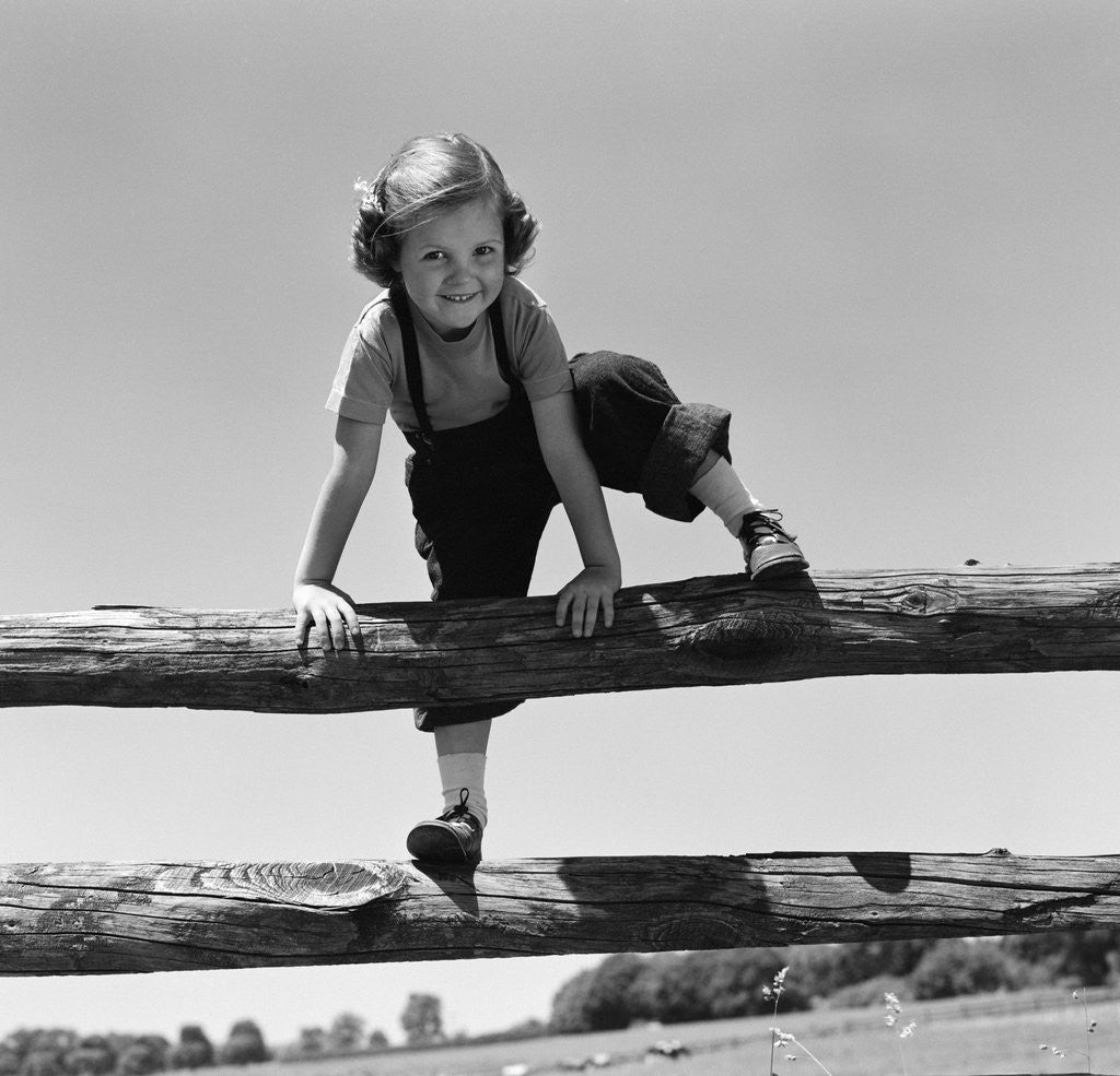 Detail of 1940s 1950s Girl Climbing Over Wooden Fence by Corbis