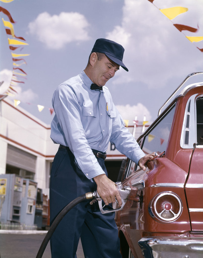 Detail of 1950s 1960s Service Station Attendant With Gasoline Pump Hose Filling Gas Tank Of Automobile by Corbis