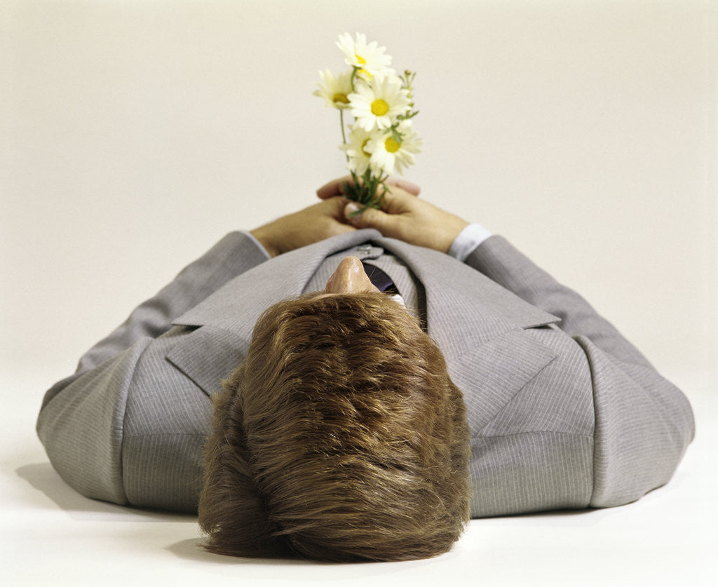 Detail of 1970s Man Lying Down Pushing Up Daisies by Corbis