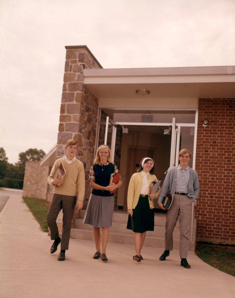 Detail of 1960s Four Teenage Students Walking Out Of Suburban High School Building Carrying Books by Corbis