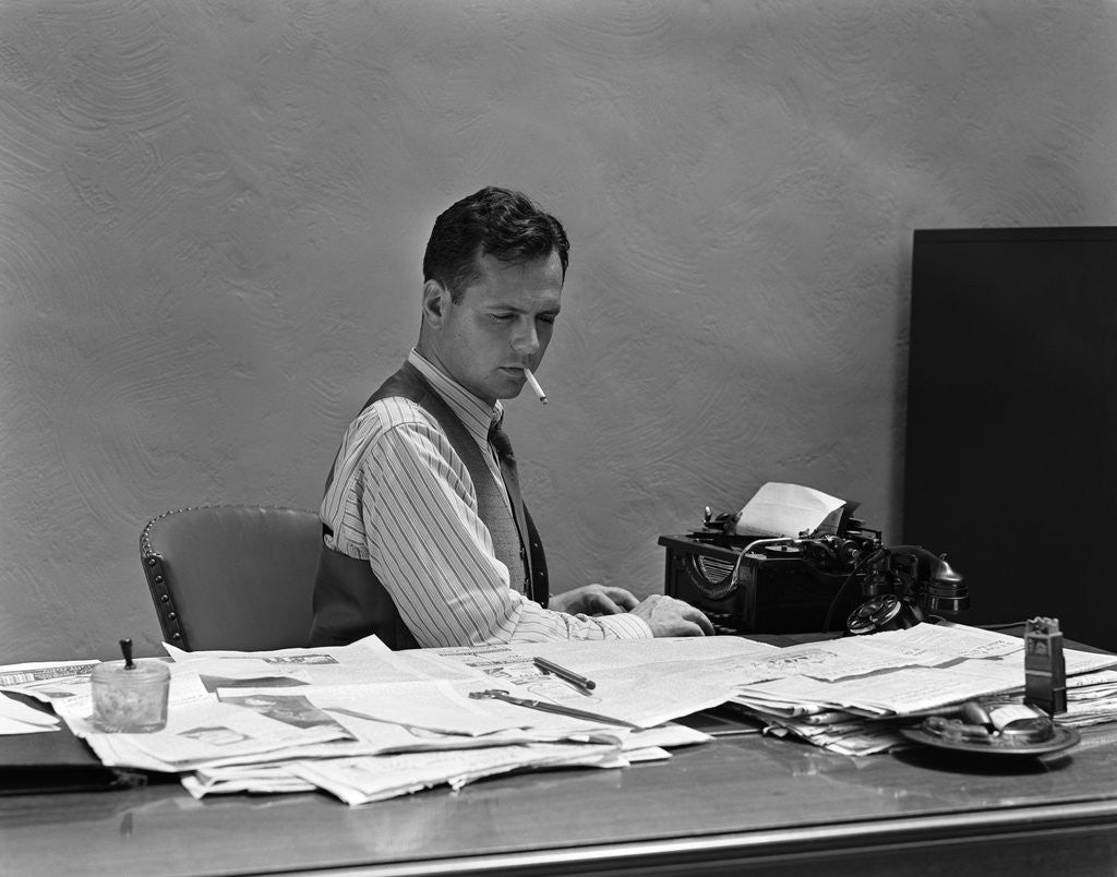 Detail of 1930s 1940s Busy Man In Shirt Sleeves Behind Office Desk Working At Typewriter Smoking Cigarette by Corbis