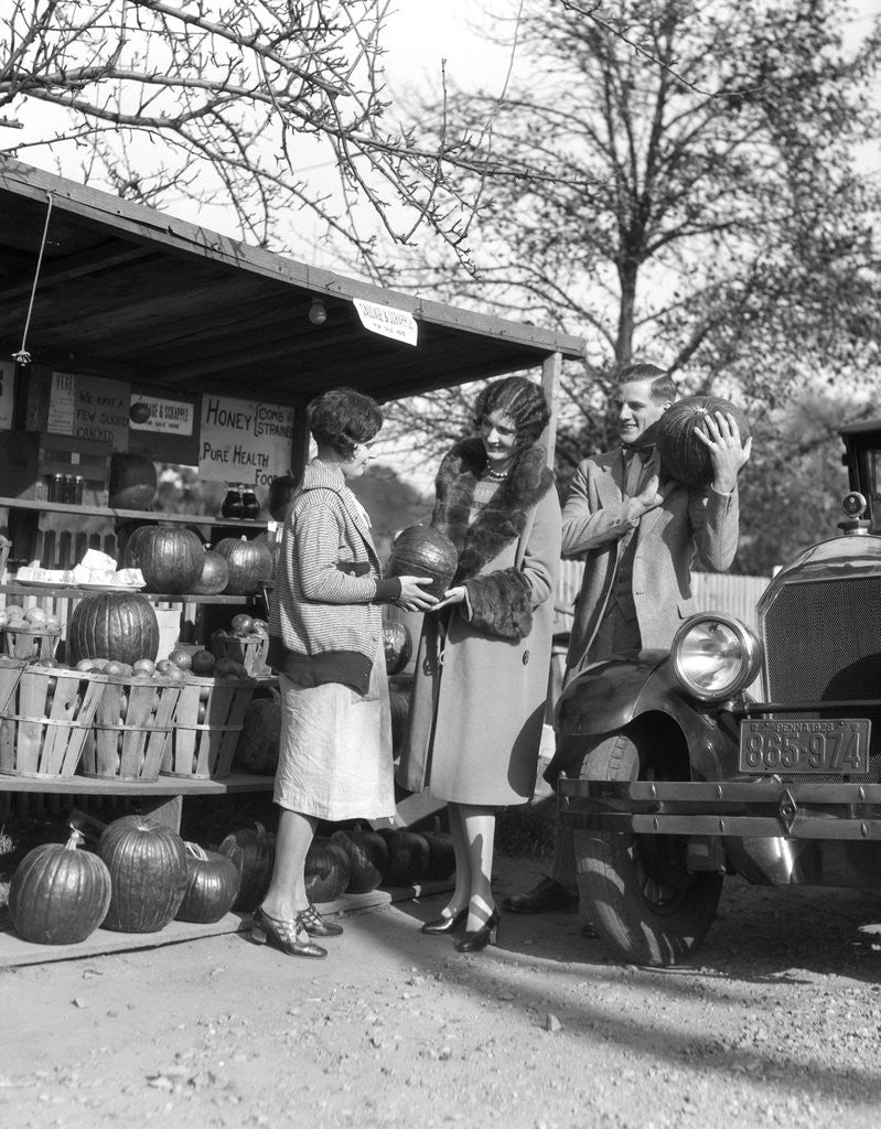 Detail of 1920s Couple Women Man At Roadside Produce Stand Buying Pumpkins by Corbis