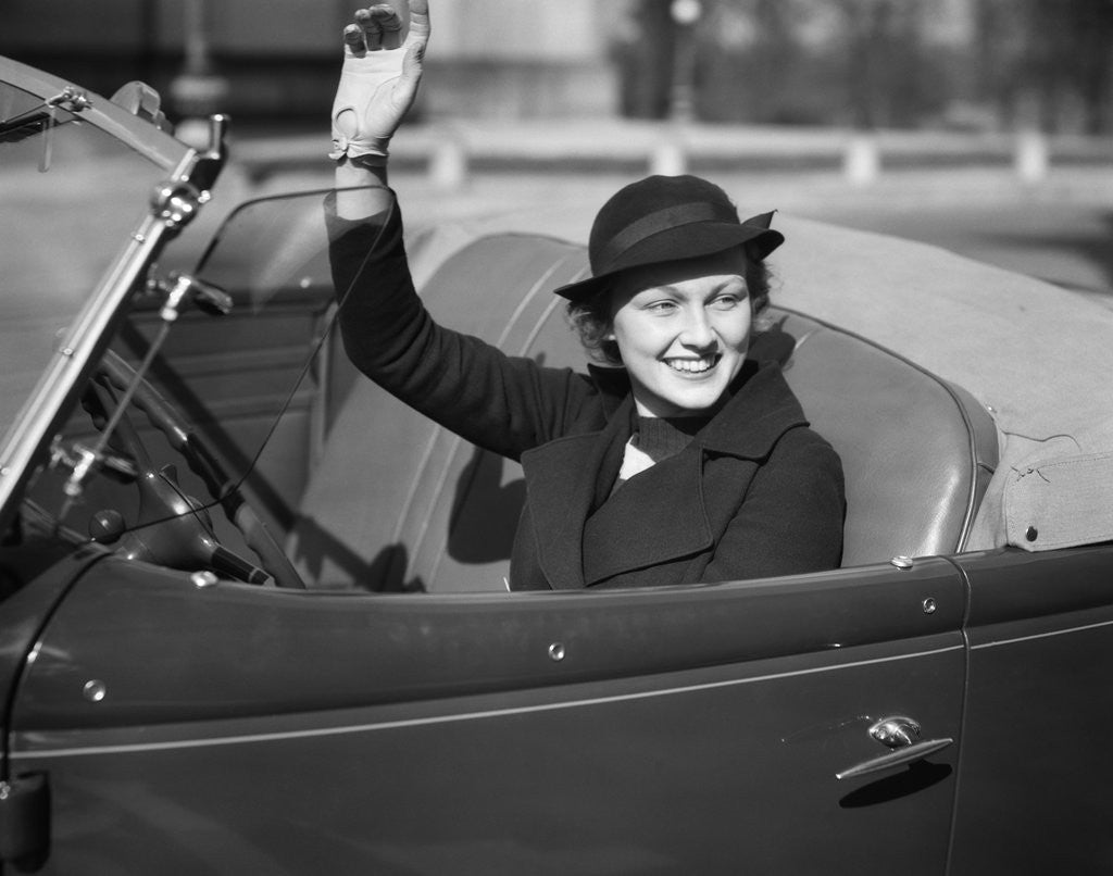 Detail of 1930s Woman Driving Convertible Roadster Automobile Waving Gloved Hand by Corbis