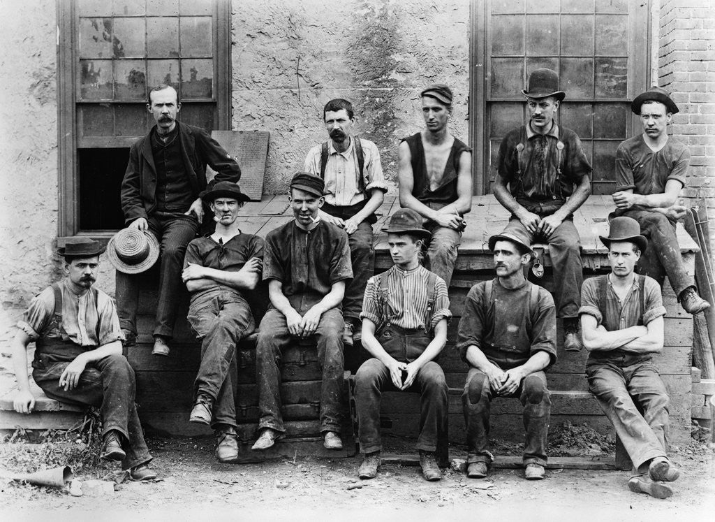 Detail of 1890s Factory Workers Seated Outside Of Building by Corbis