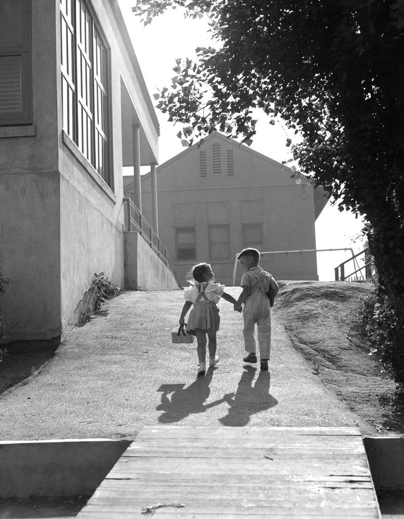 Detail of 1940s 1950s Two School Children Boy And Girl Walking To School Holding Hands by Corbis