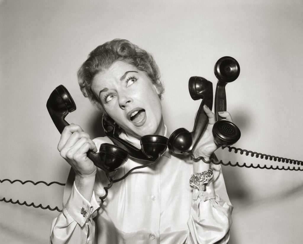 Detail of 1950s 1960s Overwhelmed Stressed Woman Answering Four Black Telephone Phone Receivers At One Time by Corbis