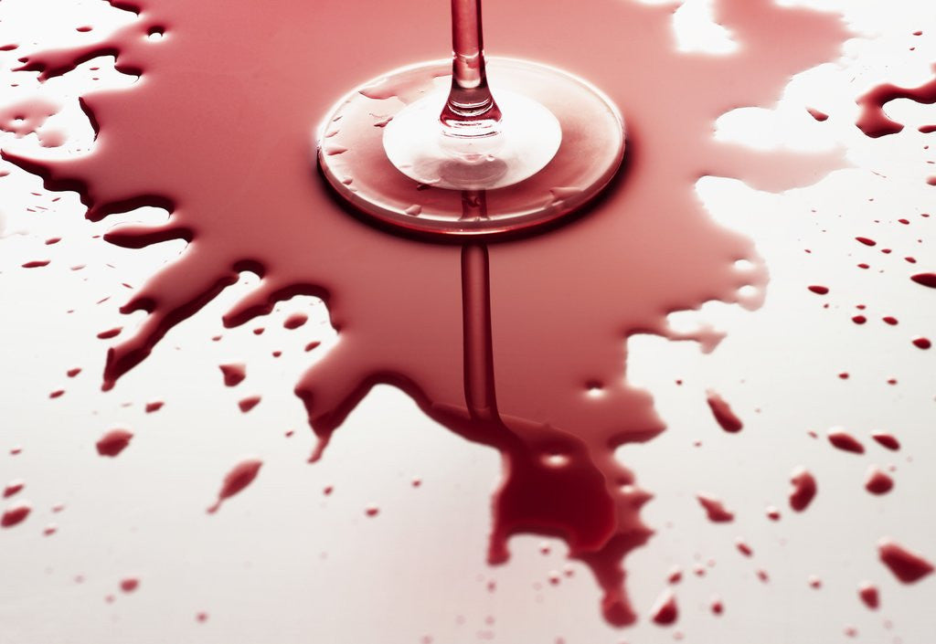 Detail of Red wine spilled around glass by Corbis