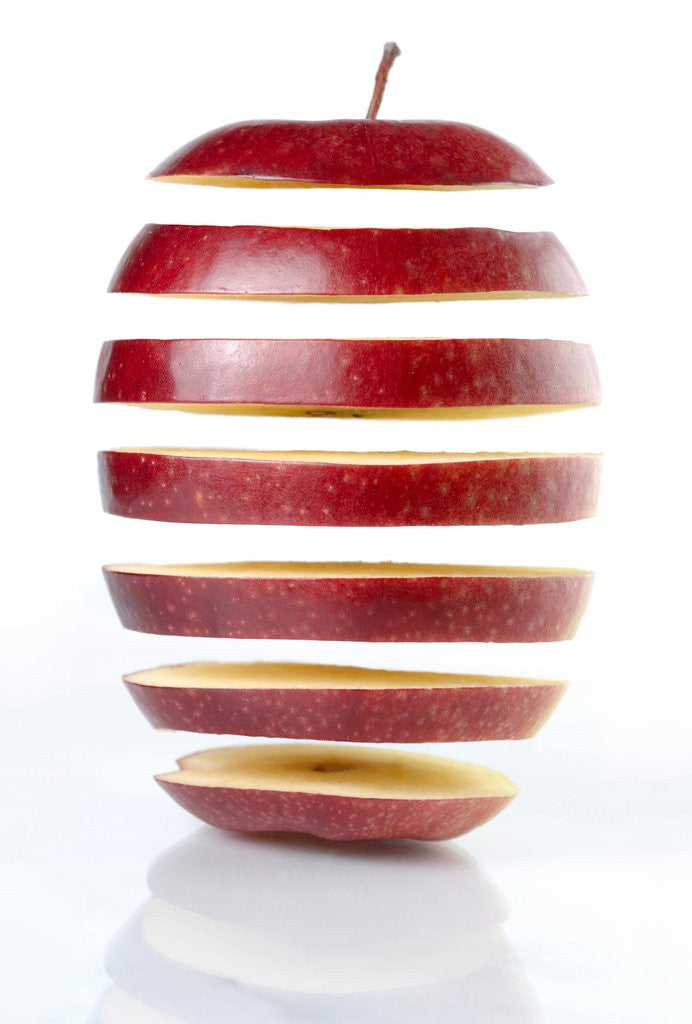 Detail of Conceptual Photo of a Sliced on Seven Parts and Disassembled Red Apple Silhouette on White Background Genetically Modified Food Gene Engineering Abstract Concept by Corbis