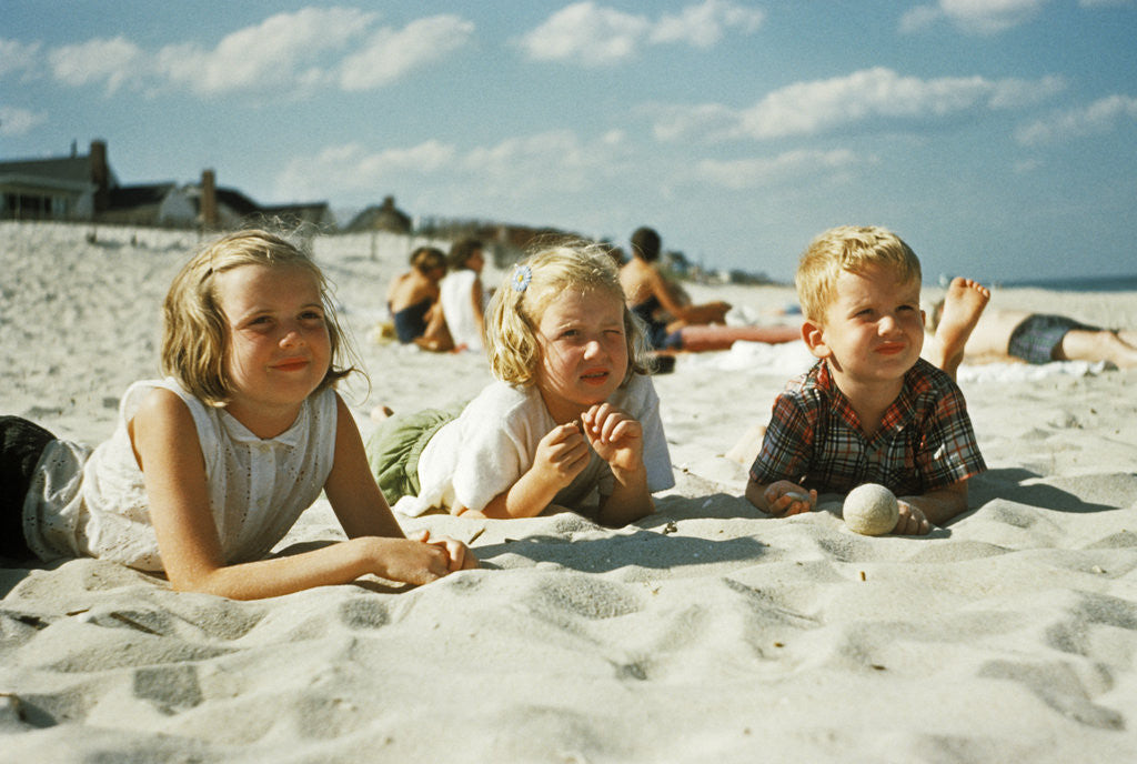 Detail of 3 children lying on the beach at the jersey shore by Corbis