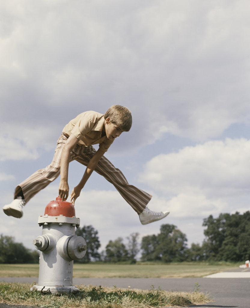 Detail of Boy jumping over fire hydrant by Corbis