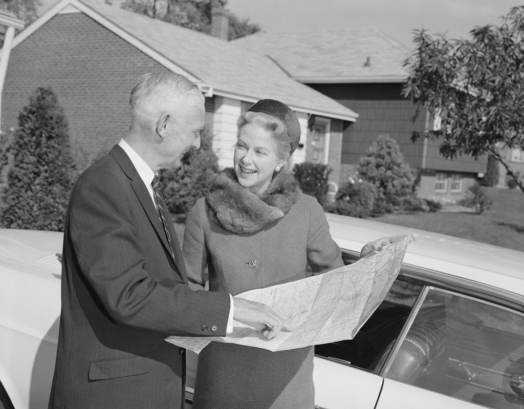 Detail of Senior man and woman by car looking at map by Corbis