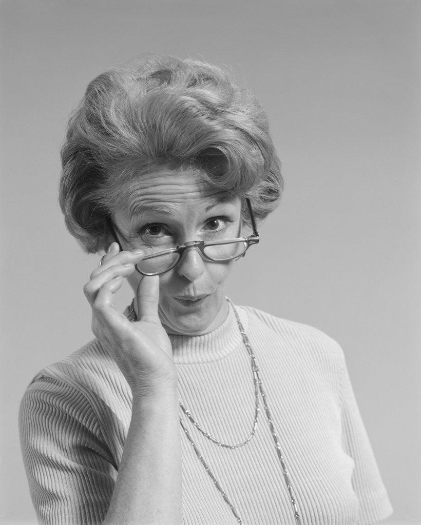 Detail of Mature woman looking over the top of her eyeglasses funny facial expression by Corbis