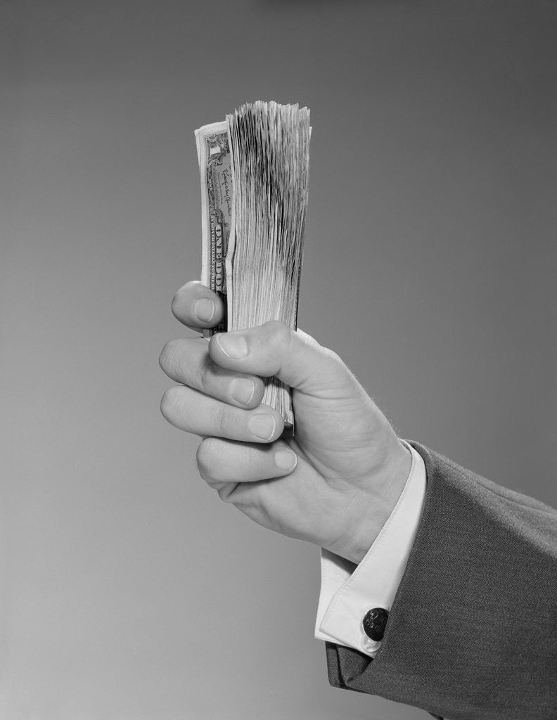 Detail of Male hand holding a fistful dollars cash money by Corbis