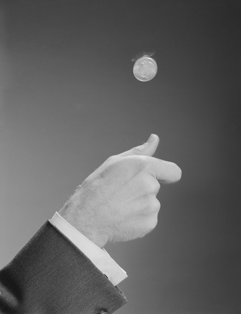 Detail of Male hand tossing flipping a coin by Corbis