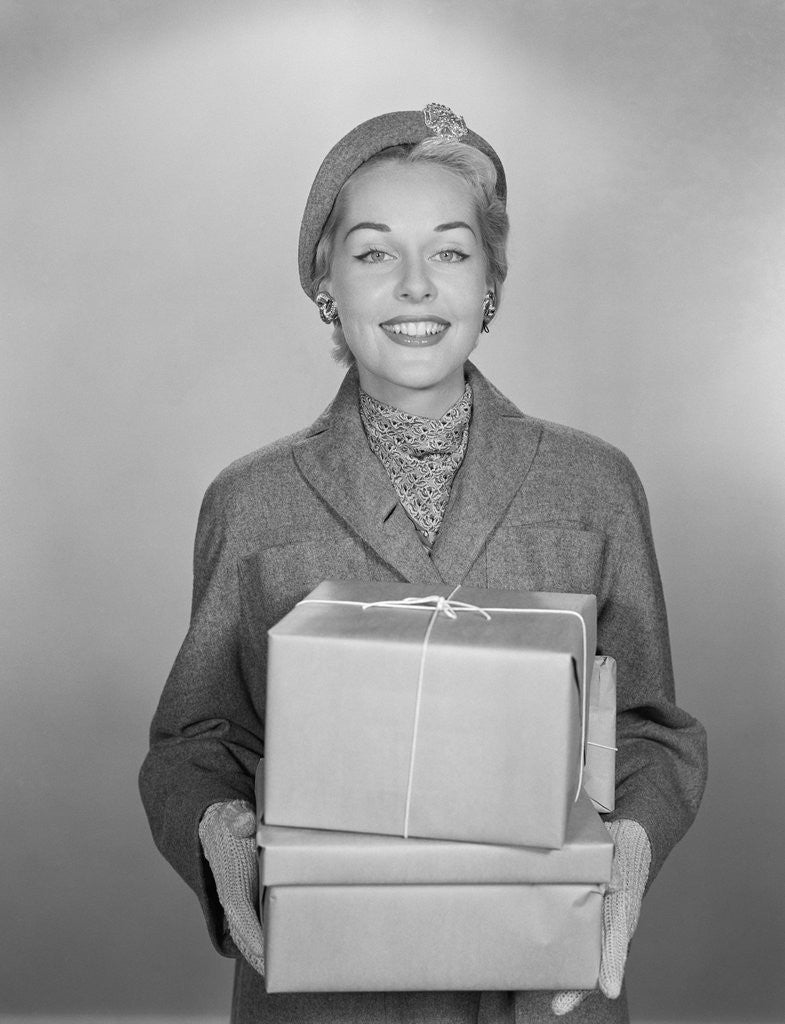 Detail of Fashionably dressed woman holding packages wrapped in brown paper and string by Corbis