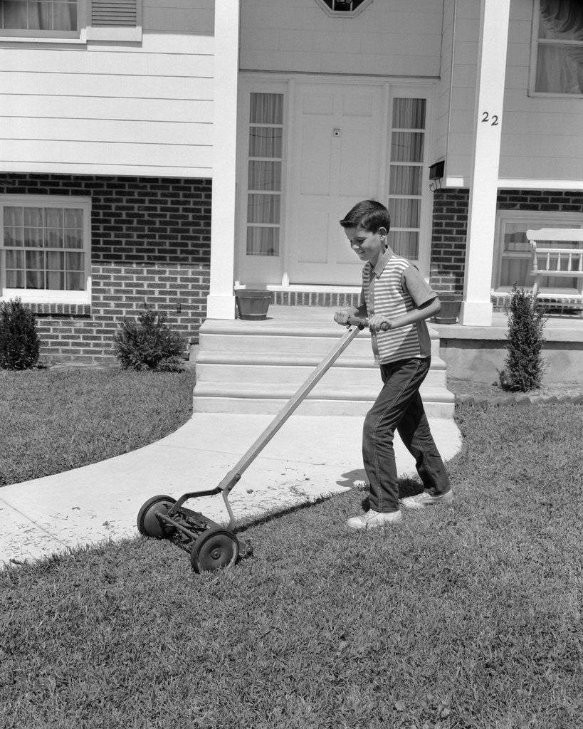 Detail of 1960s boy cutting mowing suburban home front yard lawn by Corbis