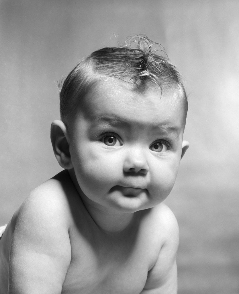 Detail of 1950s cute smirking baby looking at camera by Corbis