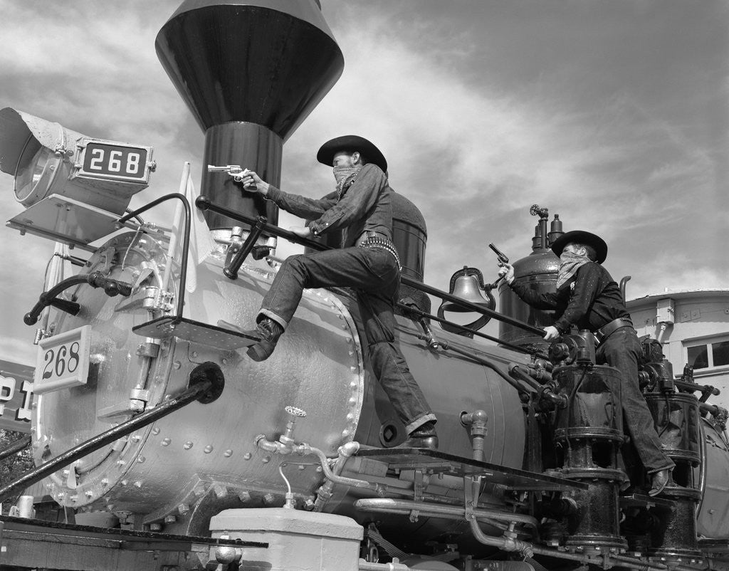 Detail of 1950s 1960s two cowboy bandits western train robbery shoot out by Corbis