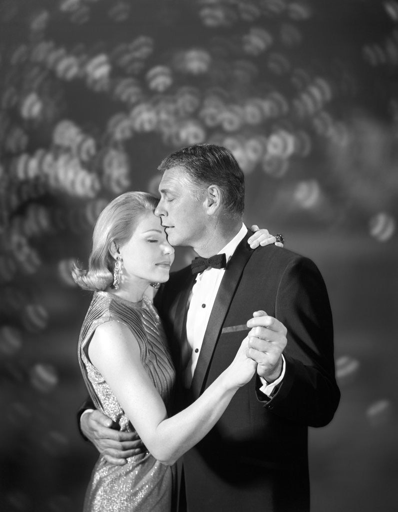 Detail of 1960s couple woman in evening dress and man in tuxedo slow dancing by Corbis