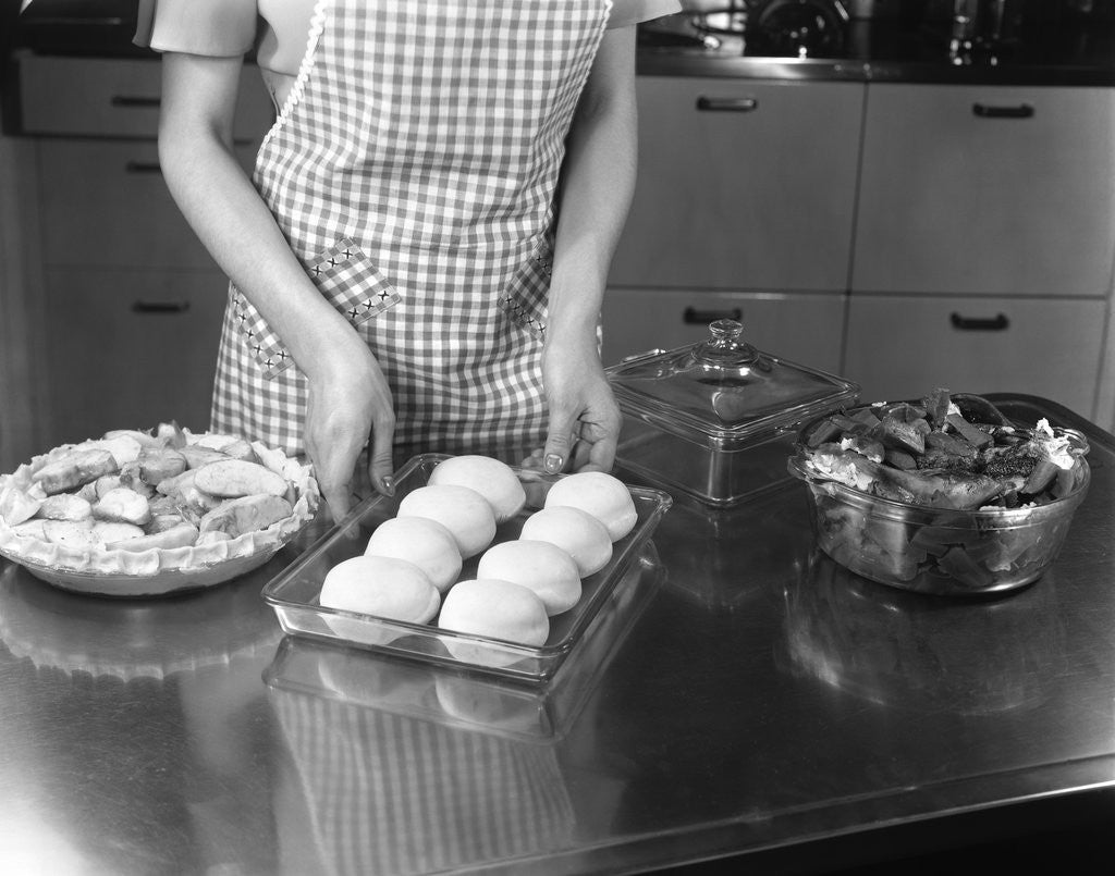 Detail of 1940s 1950s woman preparing dinner baking rolls and pie by Corbis