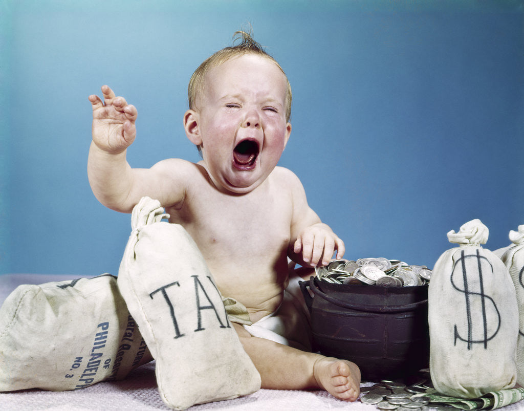 Detail of 1960s baby crying shouting screaming with bags of money and bag labeled tax by Corbis