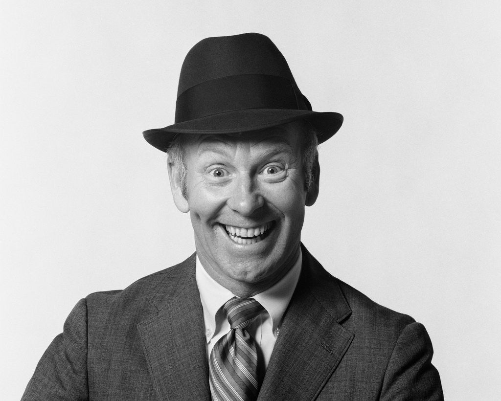 Detail of 1960s man smiling wearing suit and hat with silly eager facial expression by Corbis