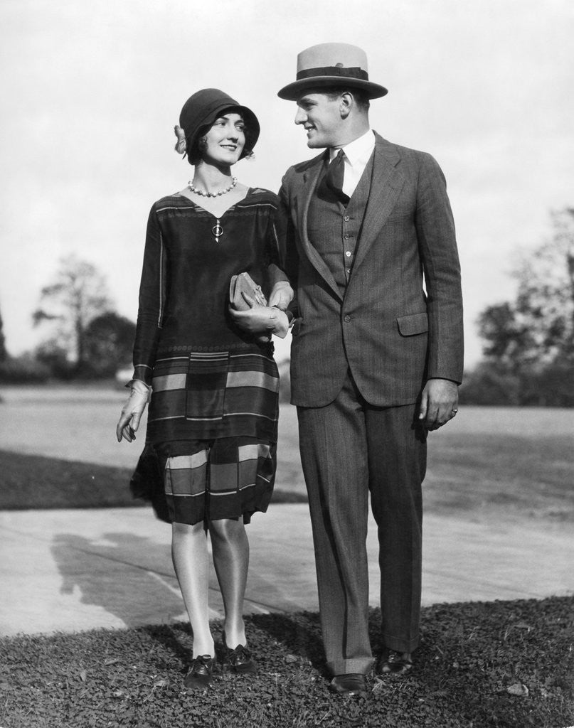 Detail of 1920s Portrait Smiling Stylish Couple Walking Arm In Arm by Corbis