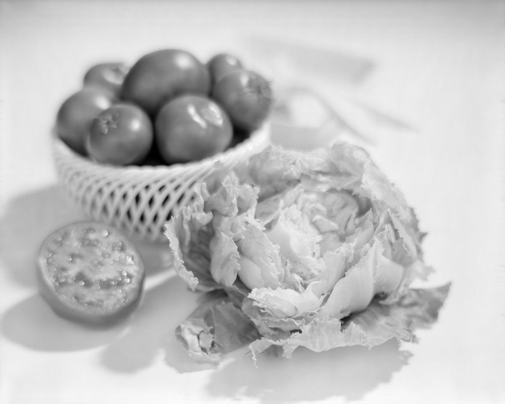 Detail of 1950s Fresh Sliced Tomato And Head Of Iceberg Lettuce To Make A Salad by Corbis