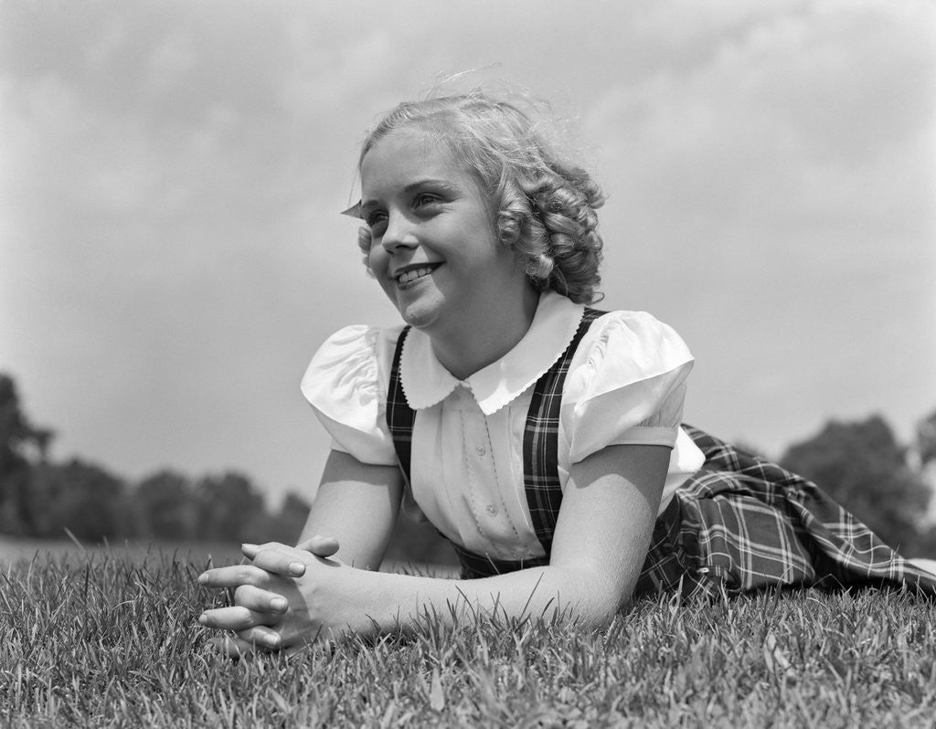 Detail of 1940s Blond Girl Smiling Lying On Grass by Corbis