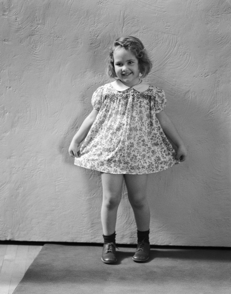 Detail of 1940s Little Girl Wearing Floral Print Dress Ready To Take A Bow by Corbis