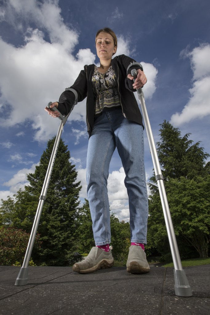 Detail of Woman standing on crutches by Corbis