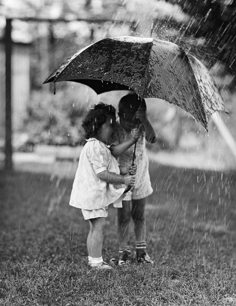 Detail of Two Children Under Umbrella During a Downpour by Corbis